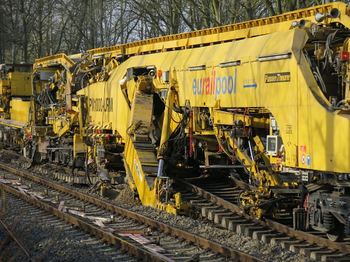 Die Aushubmaschine B der PM 1000 URM im Einsatz. Gut zu sehen sind die beiden Aushubketten, die zuerst den Schotter und danach den Unterboden aufnehmen.